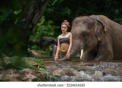 Portrait Of A Woman Standing In A River With An Elephant, Thailand
