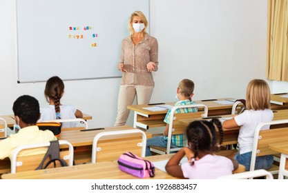 Portrait Of Woman Teacher In Protective Face Mask Explaining New Theme During Class, New Normal Education During Pandemic