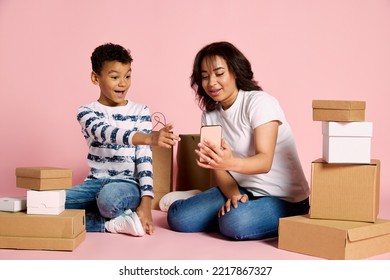 Portrait Of Woman With Teen Boy, Son Looking On Phone And Doing Shopping Online Isolated On Pink Background. Concept Of Shopping, Online Order And Delivery, Black Friday Sales. Copy Space For Ad, Text