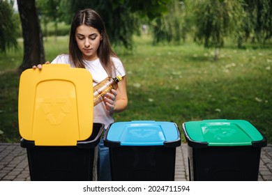 Portrait Woman Throwing Empty Plastic Water Bottle In Recycling Bin. Tree Recycling Bins Outdoors