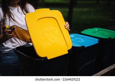 Portrait Woman Throwing Empty Plastic Water Bottle In Recycling Bin. Tree Recycling Bins Outdoors