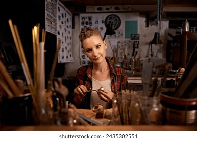 Portrait, woman and tools with wood in workshop with craftsmanship, knife or handmade design and creativity. Woodwork, carpenter or creative person at workspace with equipment for handicraft or hobby - Powered by Shutterstock