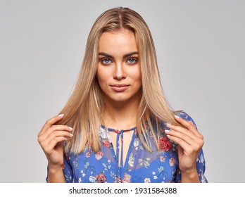 Portrait Of Woman Touching Her Blonde Hair Isolated On Gray Background