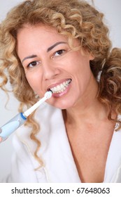 Portrait Of Woman Using Electric Toothbrush