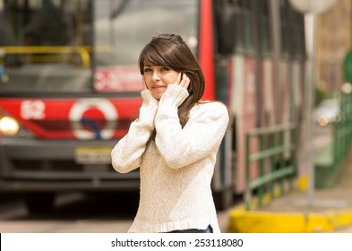 portrait of woman walking on the city street covering her ears concept of noise pollution