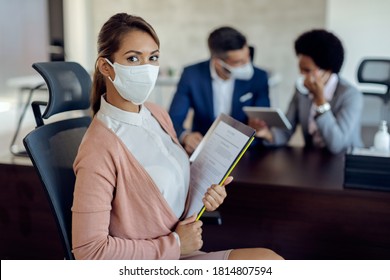 Portrait of a woman wearing a face mask while having job interview in the office during coronavirus epidemic. 