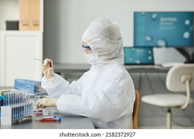 Portrait Of Woman Wearing Full Protective Gear While Holding Petri Dish In Medical Laboratory, Copy Space