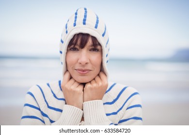 Portrait of woman wearing hooded sweater at beach during winter - Powered by Shutterstock