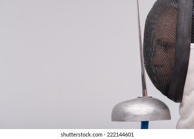 Portrait of woman wearing white fencing costume standing aside holding the sword in front of her. Isolated on white background - Powered by Shutterstock