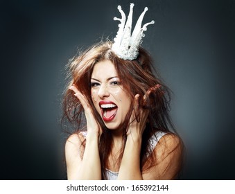 portrait of woman wearing white princess crown with funny and crazy expression on her face