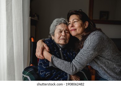 Portrait of woman in wheelchair hugging daughter with positive face. Third age, Home care concept.