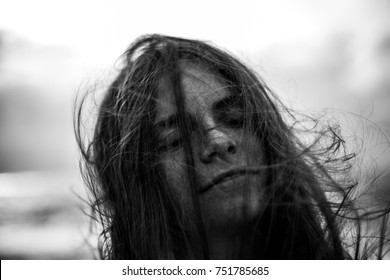 Portrait of woman with windy hair and closed eyes. Feel free, forget about your problems. Black and white photo