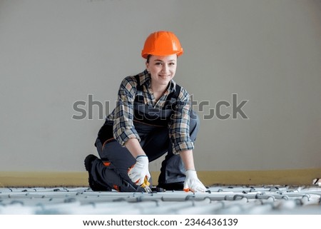 Portrait of woman worker which is installing underfloor heating system. Warm floor heating system.