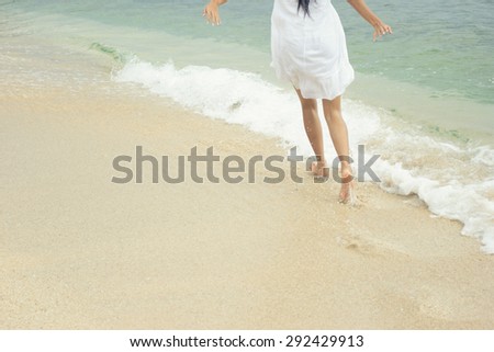 A portrait of woman's foot running on the sandy beach - Selective focus