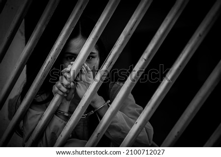 Portrait of women desperate to catch the iron prison,prisoner concept,thailand people,Hope to be free,If the violate the law would be arrested and jailed.