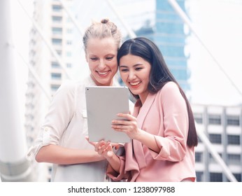 Portrait Women Look At IPad And Laughing Together.