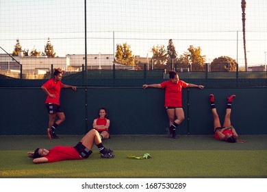 Portrait Of Womens Football Team Relaxing After Training For Soccer Match On Outdoor Pitch