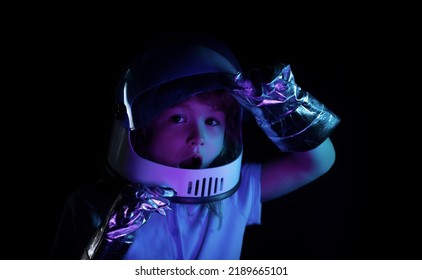 Portrait Of Wondered Little Astronaut In Helmet And Protective Space Suit. Close Up Excited Kids Face On Neon Color.