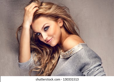 Portrait of wonderful young blonde woman with long hair looking at camera, smiling.