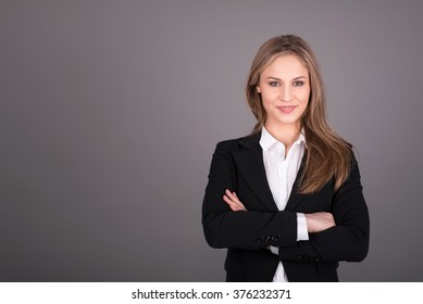 Portrait of wonderful young business woman on gray background with copy space