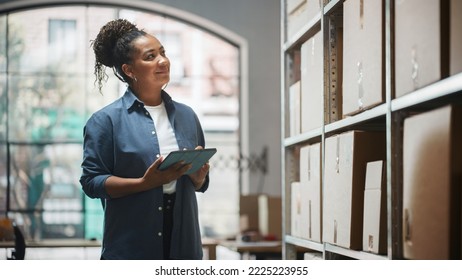 Portrait of a Worker Checking Inventory, Writing in Tablet Computer. Black Woman Working in a Warehouse Storeroom with Rows of Shelves Full of Parcels, Packages with Orders Ready for Shipment. - Powered by Shutterstock