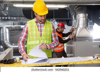 Porträt eines Arbeitnehmers, Bau und Prüfung der Entwicklung eines kleinen Betriebshauses. zuverlässiger Ingenieur, der auf einer Baustelle arbeitet, der Vorarbeiter bei der Arbeit