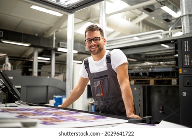 Portrait of worker at control room checking print quality at printing house.