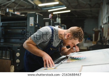 Portrait of worker at control room checking print quality at printing house
