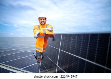 Portrait Of Worker Expert Standing On The Roof Leaning Against Solar Panel And Smiling.