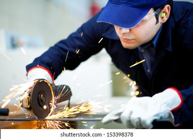Portrait of a worker grinding a metal plate 