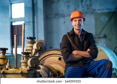 Portrait Of A Worker In The Helmet Near The Steam Turbine