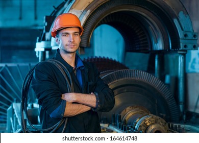 Portrait Of A Worker In The Helmet Near The Turbine.