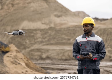 Portrait worker man American African adult engineer using drone technology for sand mining survey in quarry and open mine.