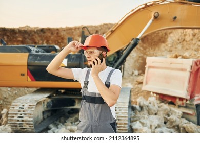 Portrait of worker in professional uniform that is on the borrow pit at daytime.