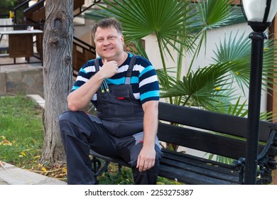 Portrait of a working man 40-44 years old sitting on a bench., - Shutterstock ID 2253275387