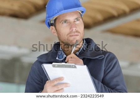 portrait of workman preparing estimate for work on house