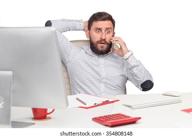 Portrait Of Worried Businessman Sitting And Talking On Mobile Phone In Office