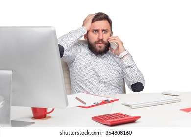 Portrait Of Worried Businessman Sitting And Talking On Mobile Phone In Office