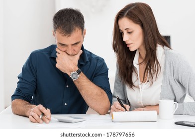 Portrait Of A Worried Couple Calculating Financial Budget