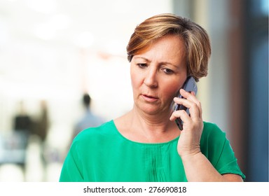 Portrait Of A Worried Mature Woman Talking On Telephone