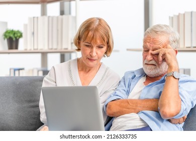 Portrait Of Worried Senior Couple Checking Their Bills And Work On Netbook Read Document Information At Home, Serious Retired Elderly Old Family Reading Documents With Laptop