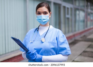 Portrait Of Worried Stressed Female Medical Doctor,standing Outside The Clinic Or Hospital Facility,burnout From Long Night Shifts,concerned Look On Her Face Looking Into Camera,insecure Future Ahead