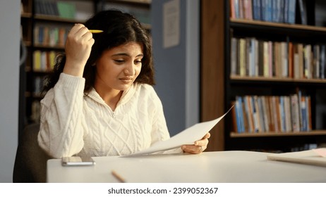 Portrait of worried young indian student working on difficult test which did not prepare at university class Upset girl feeling nervous during exams with hard program indoors Space for text