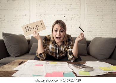 Portrait of worried young woman feeling stressed with too much credit card debts trying to manage business and home finances showing Help sign. In paying off debts, bills and financial problems.