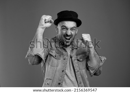 Portrait of yelling handsome man keeping his hands clenched in fists while experiencing victory emotions