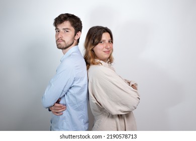 Portrait Of Young 25 Year Old Couple Back To Back Smiling And Looking At Camera. Isolated On Gray Background
