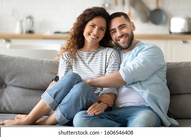 Portrait of young 35s just married couple in love posing photo shooting seated on couch in modern studio apartments, concept of capture happy moment, harmonic relationships, care and sincere feelings - Shutterstock ID 1606546408