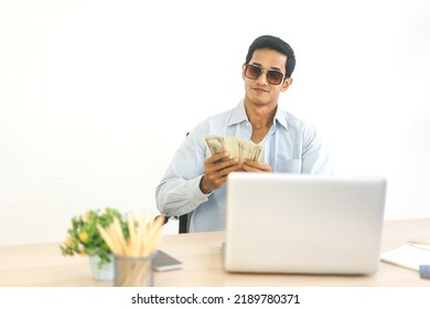 Portrait Of Young Adult Asian Rich Man Happy Face With Cash Money. Foreground With Laptop Computer For Using And Pay Via Online Concept.