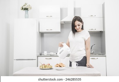 Portrait Of Young Adult Brunette Asian Woman Making Tea Or Green Tea On Kitchen Room Interior Background Food Vegetables And Cookie In White Dish Plate On Table Empty Copy Space For Inscription