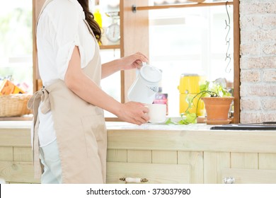 Portrait Of Young Adult Brunette Asian Woman Making Tea Or Green Tea On Kitchen Room